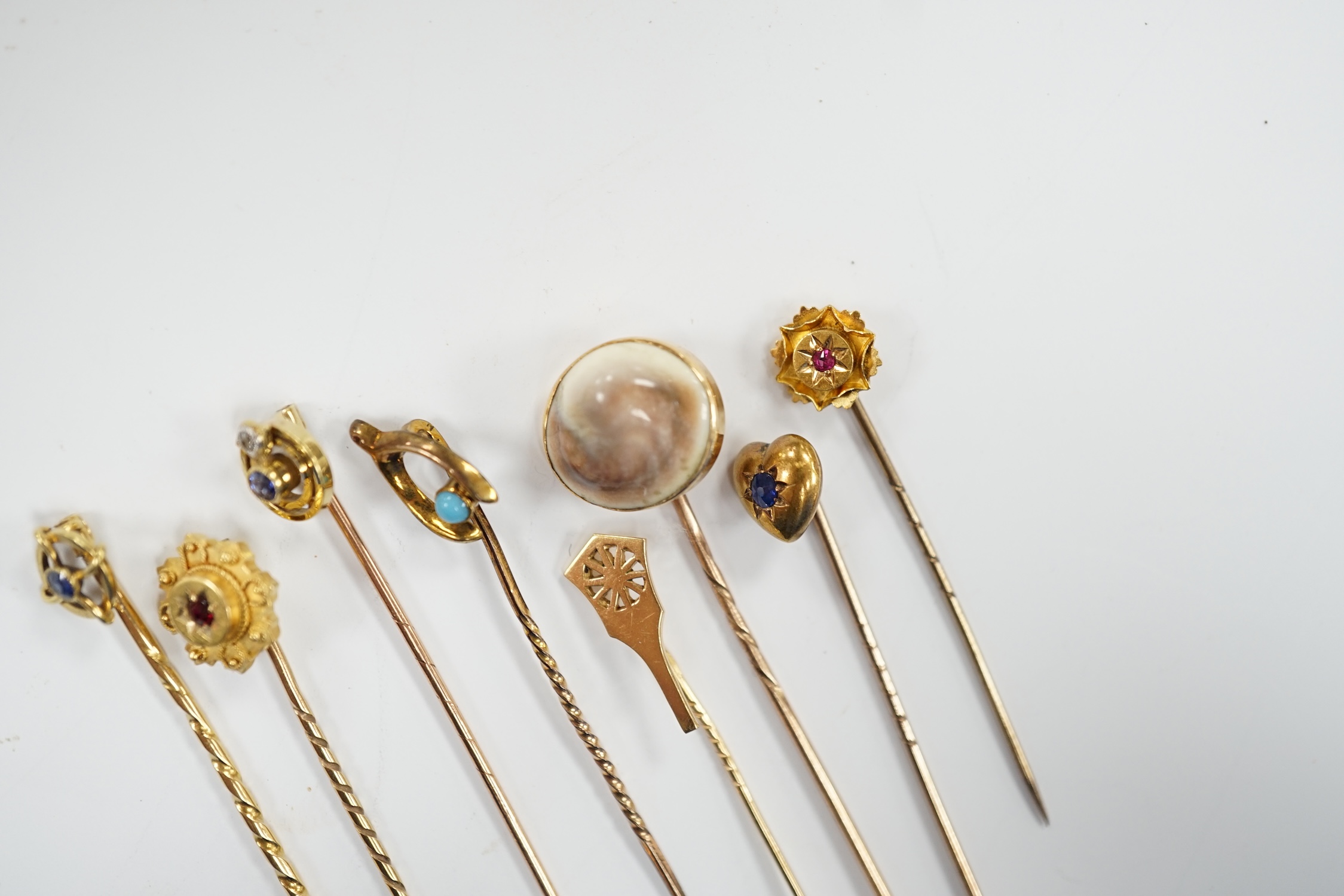 Eight assorted early 20th century and later yellow metal and gem set stick pins, including six 15ct, one 585 and one unmarked yellow metal, largest set with sapphire, 59mm, gross weight 11 grams.